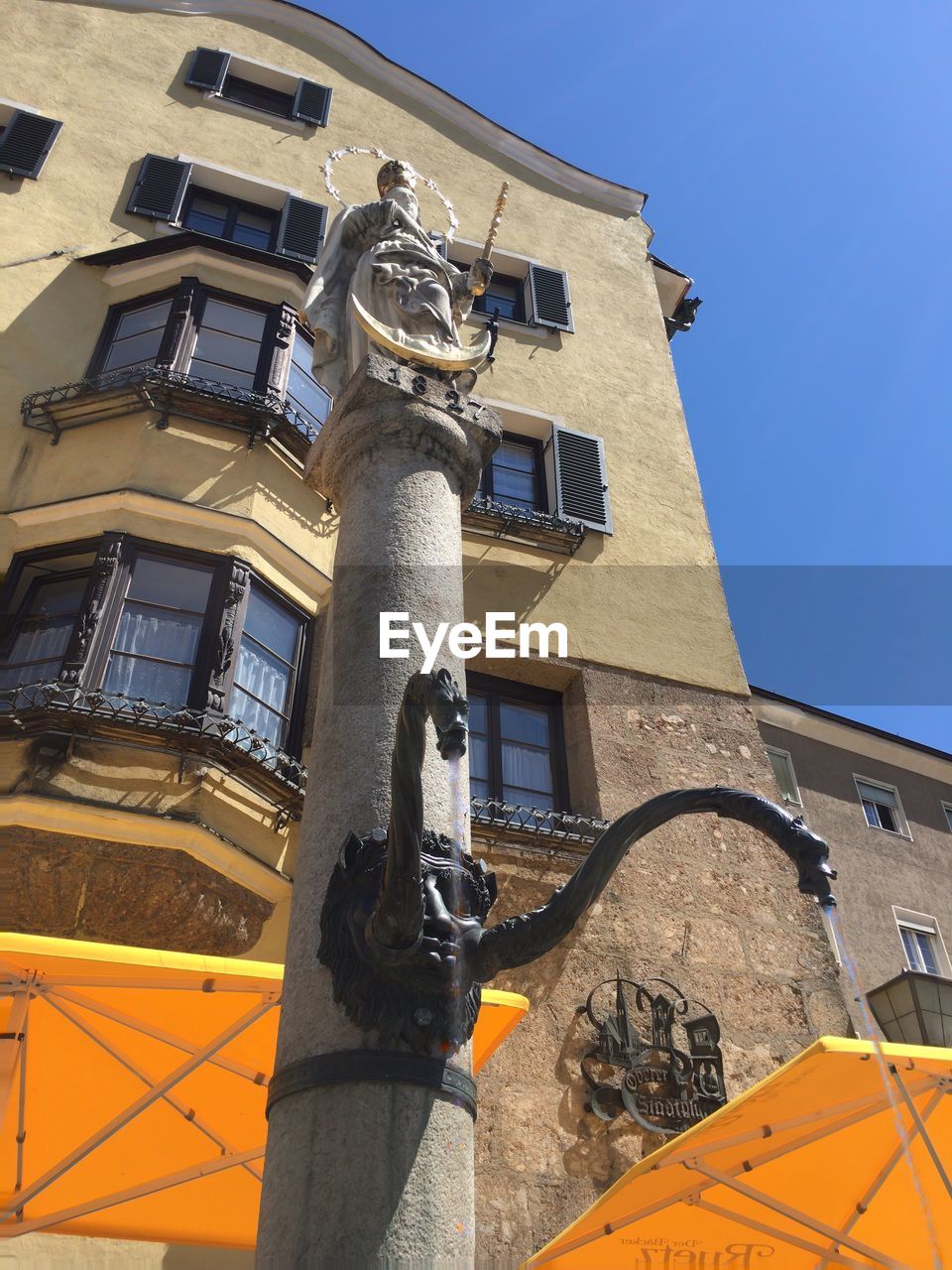 Low angle view of monument against built structure