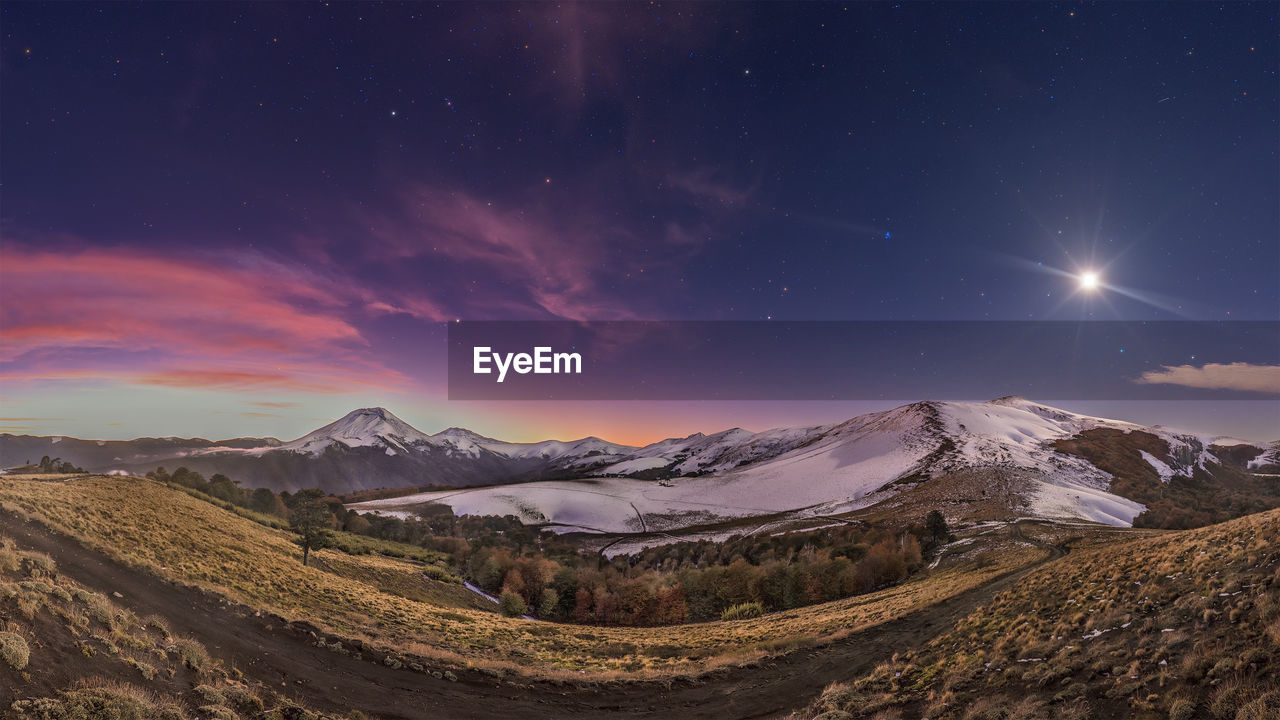 Scenic view of mountains against sky at night