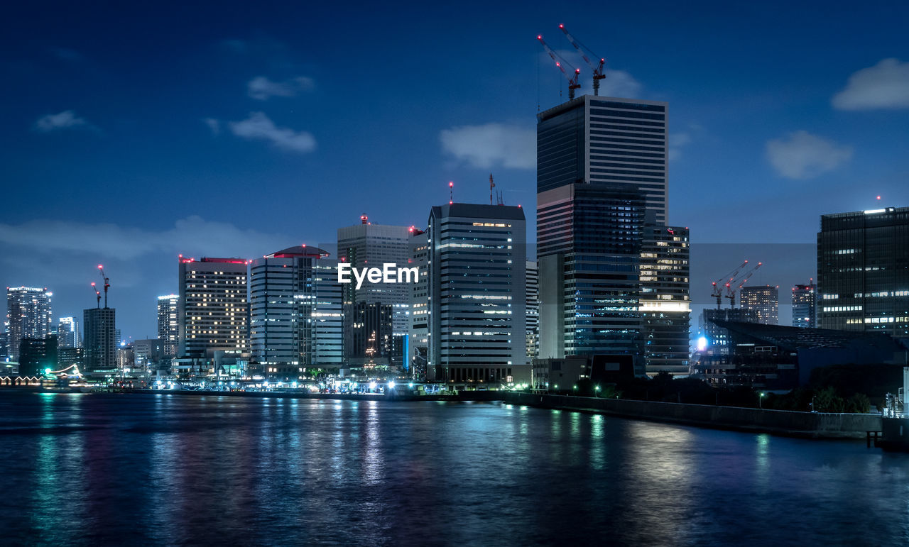 ILLUMINATED BUILDINGS IN CITY AGAINST SKY