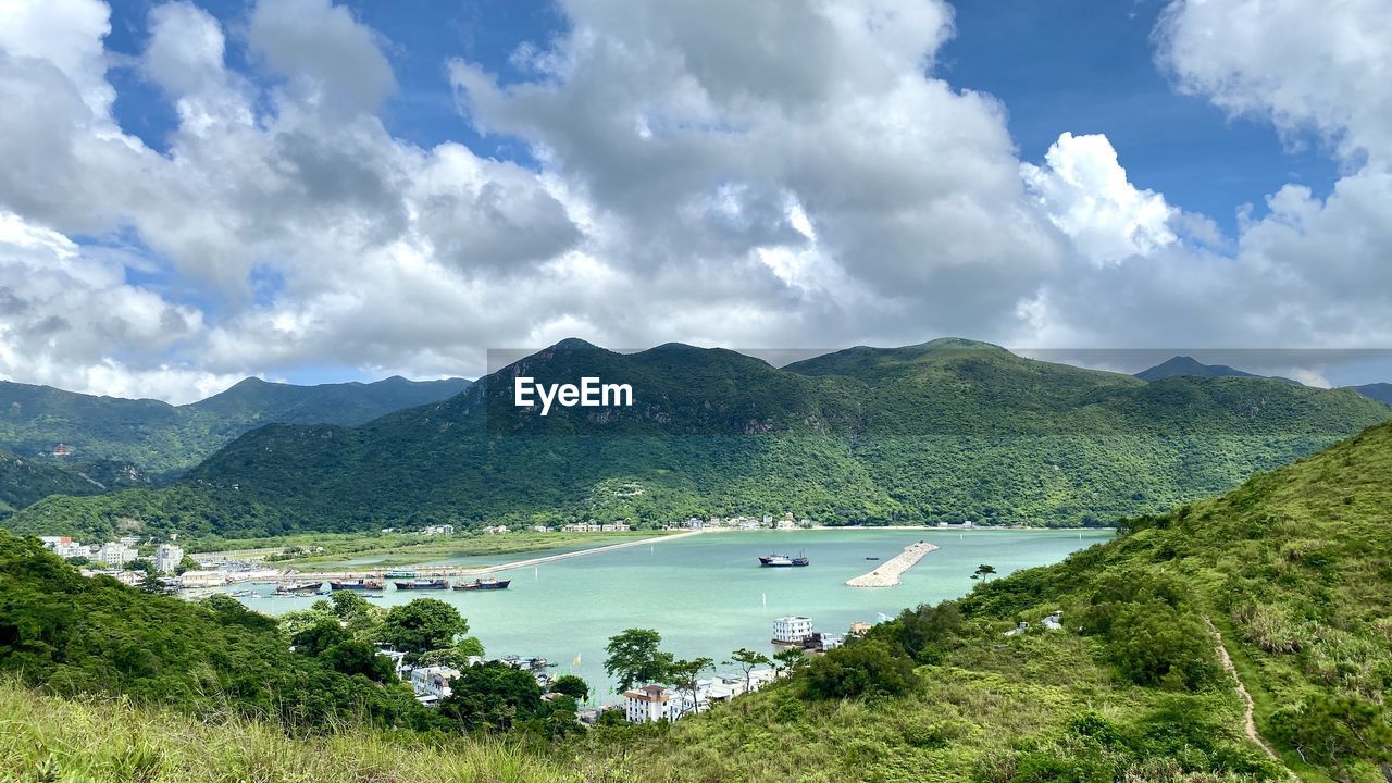 Scenic view of river and mountains against sky