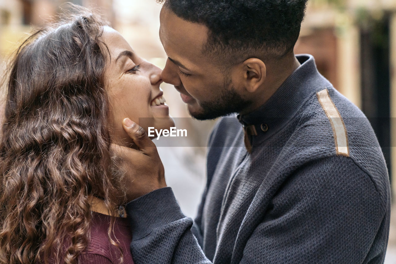 Side view of couple embracing outdoors