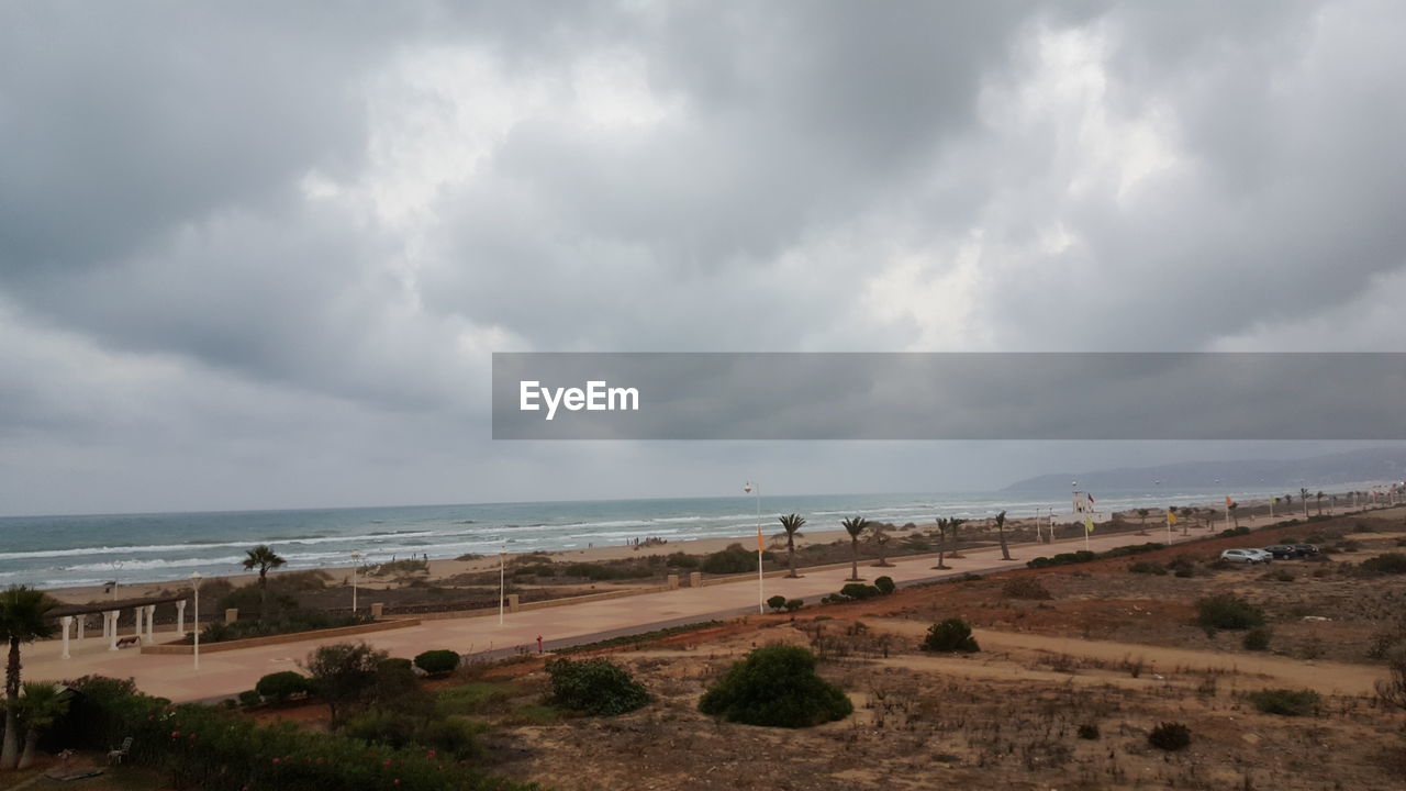 VIEW OF BEACH AGAINST CLOUDY SKY