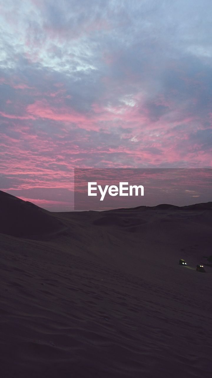 SCENIC VIEW OF SAND DUNES AGAINST SKY