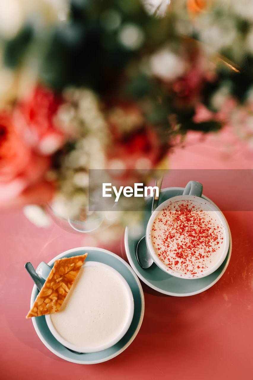 Two delicious cups of cappuccino latte with foam on the pink table in the cafe for breakfast