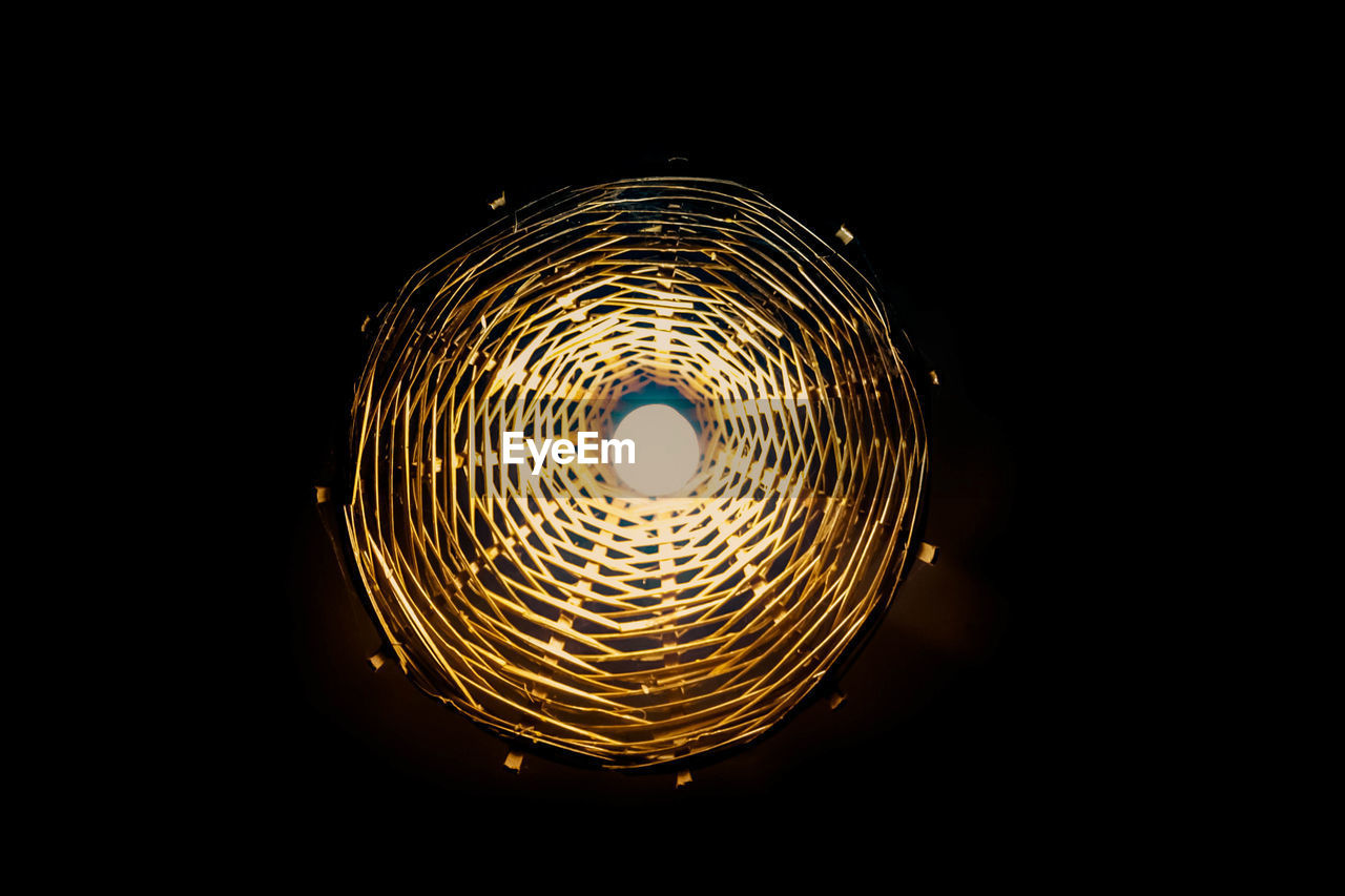 CLOSE-UP OF ILLUMINATED LAMP AGAINST BLACK BACKGROUND