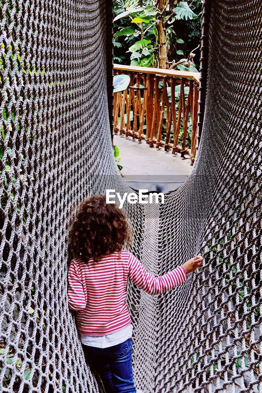 Rear view of girl playing in jungle gym