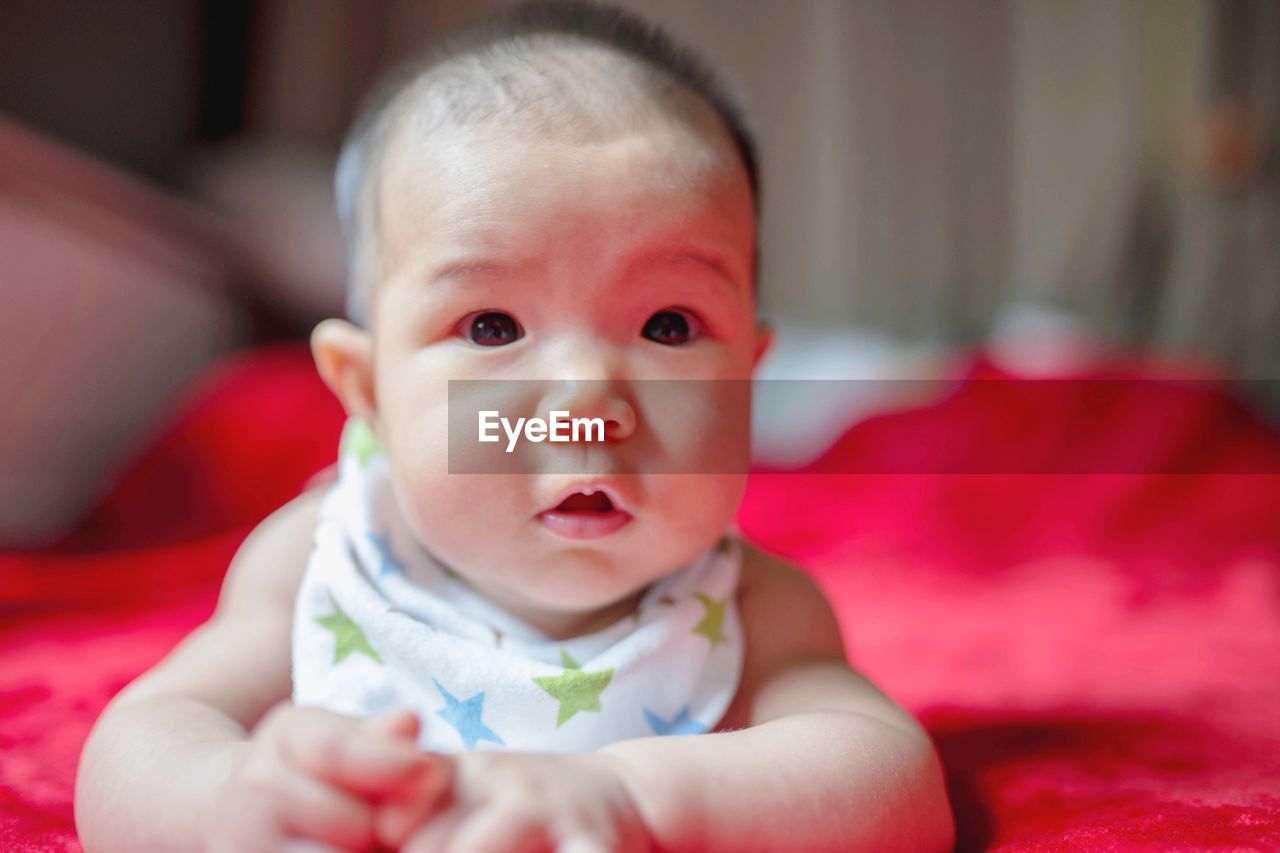 Portrait of cute baby girl on bed