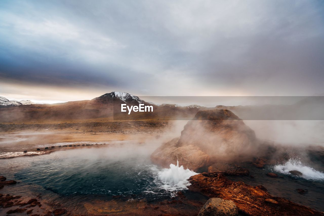 Scenic view of volcanic landscape against cloudy sky