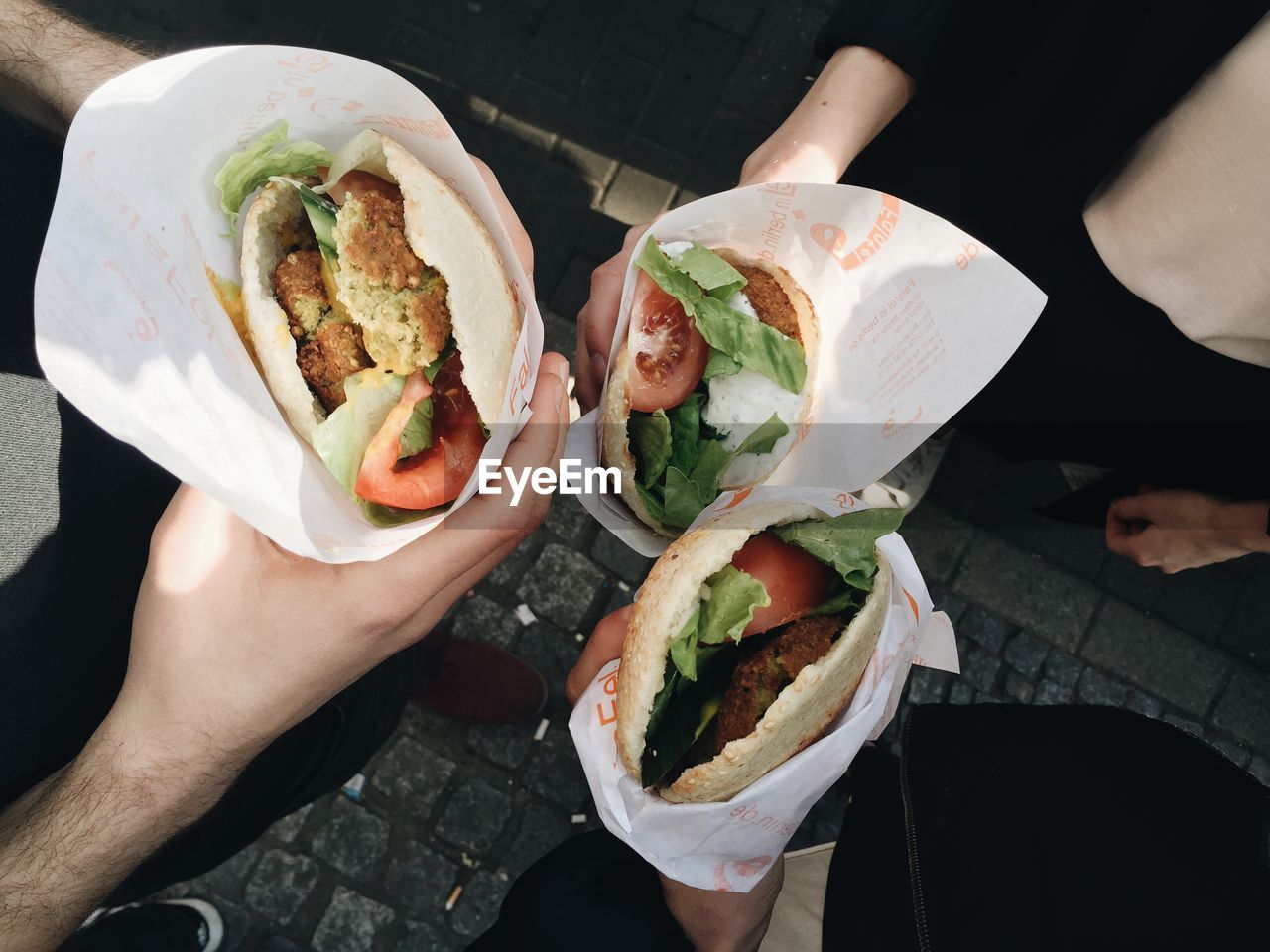 Three people holding burgers