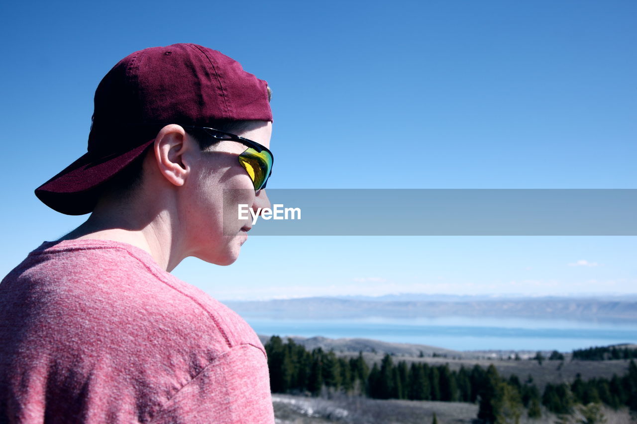 Close-up of young man wearing sunglasses while looking at view