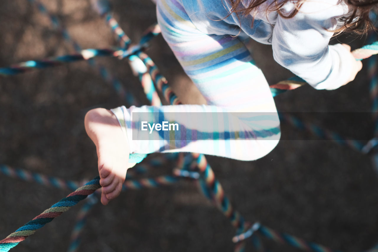 Low section of girl playing on jungle gym