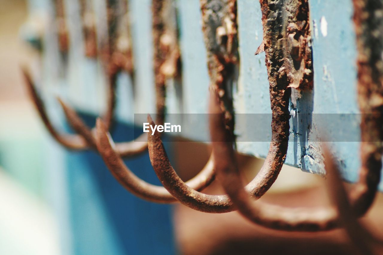 Close-up of rusty hooks on railing