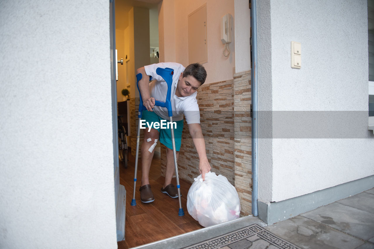 A disabled person takes out garbage