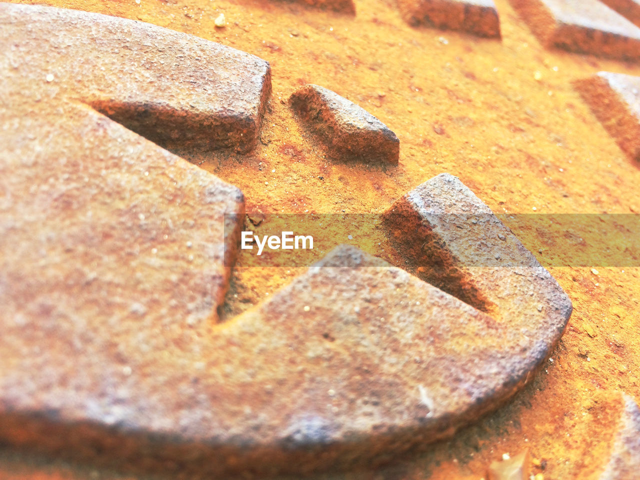 High angle view of star shape on rusty manhole