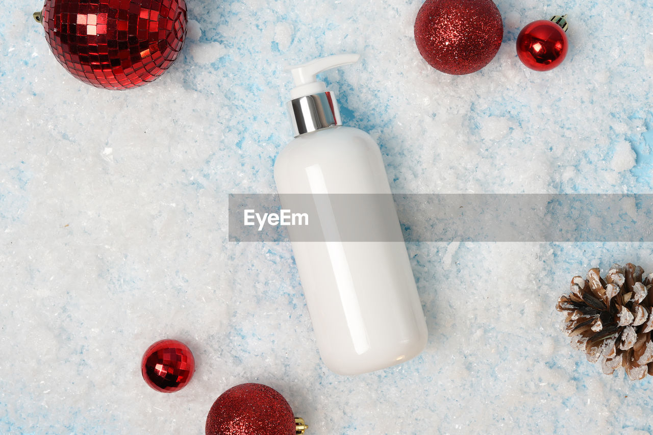 Cosmetic product lotion or shampoo on white christmas background with snow 