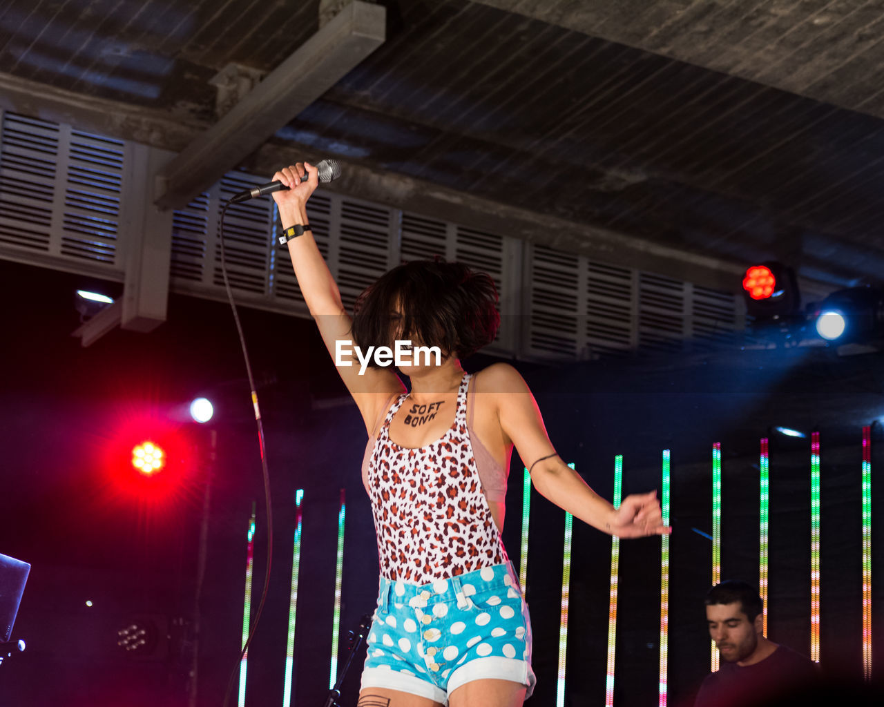 FULL LENGTH OF WOMAN STANDING AGAINST ILLUMINATED STAGE