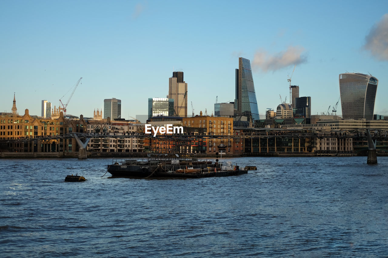 Scenic view of river by city of london against sky