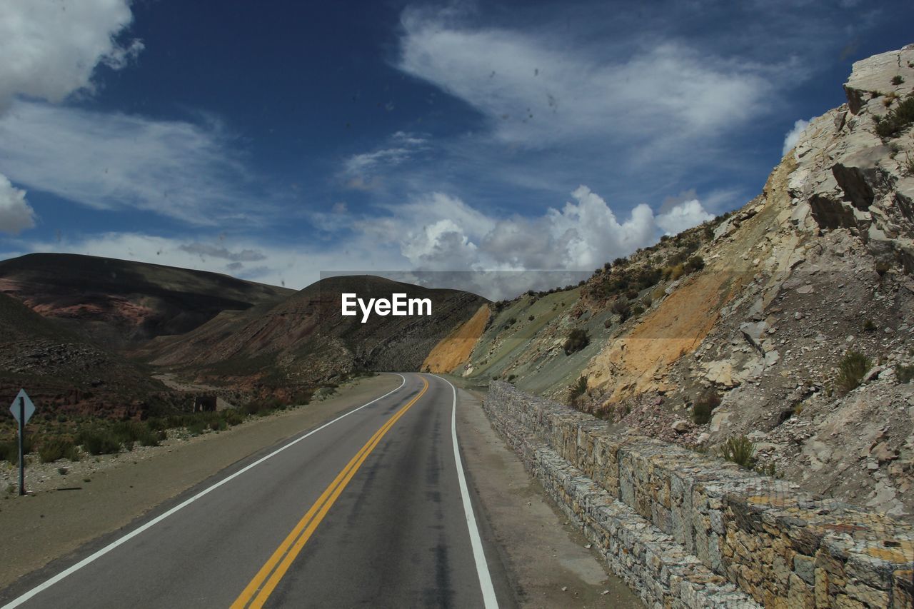 ROAD LEADING TOWARDS MOUNTAINS AGAINST SKY