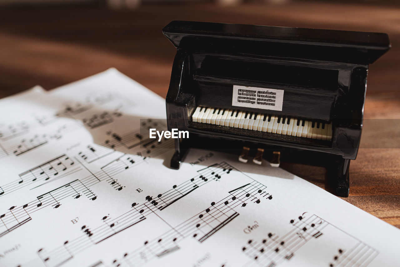 Close-up of piano with sheet music on floor