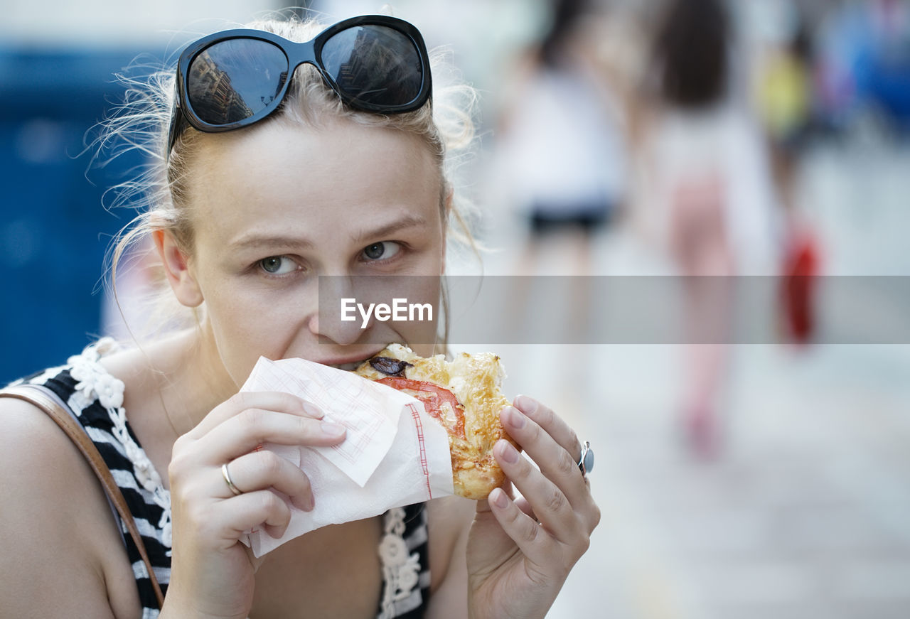 Close-up of young woman eating fast food