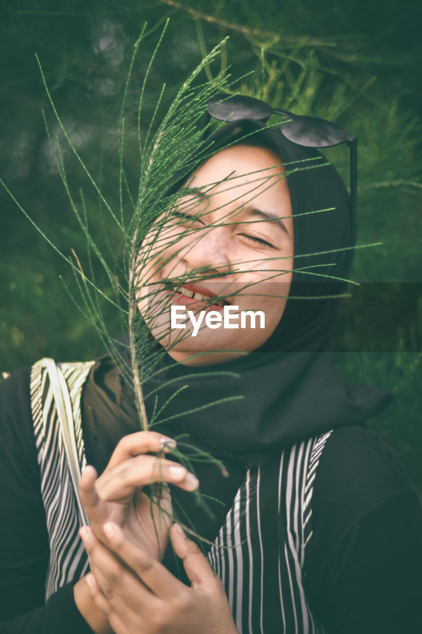 Portrait of woman holding plant