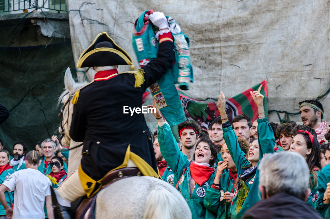 REAR VIEW OF PEOPLE STANDING IN FRONT OF AN ANIMAL