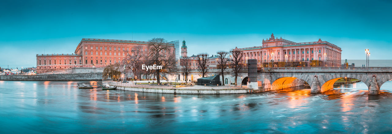 Arch bridge over river against buildings in city