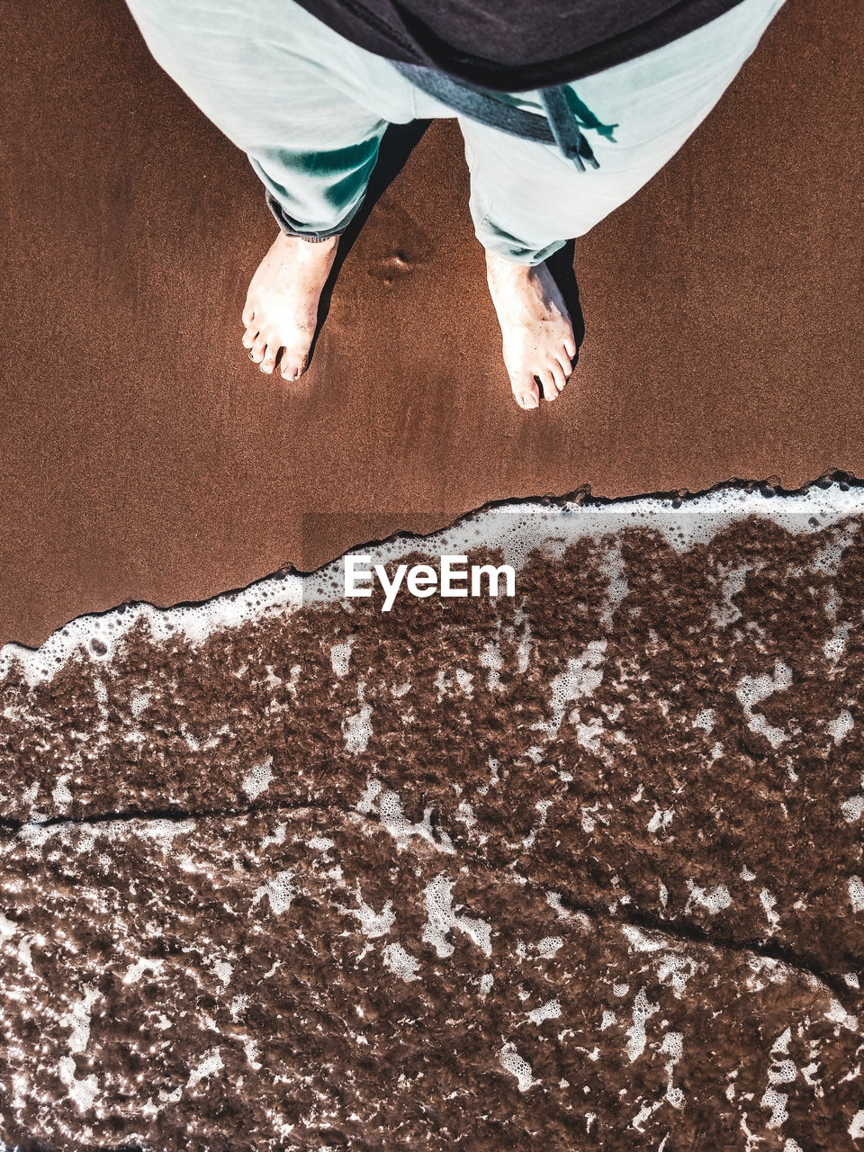 Low section of person standing on beach