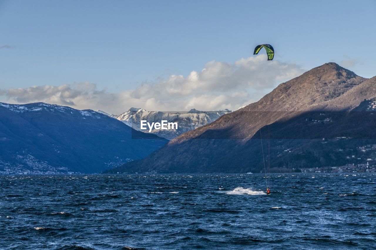 SCENIC VIEW OF SEA BY SNOWCAPPED MOUNTAIN AGAINST SKY