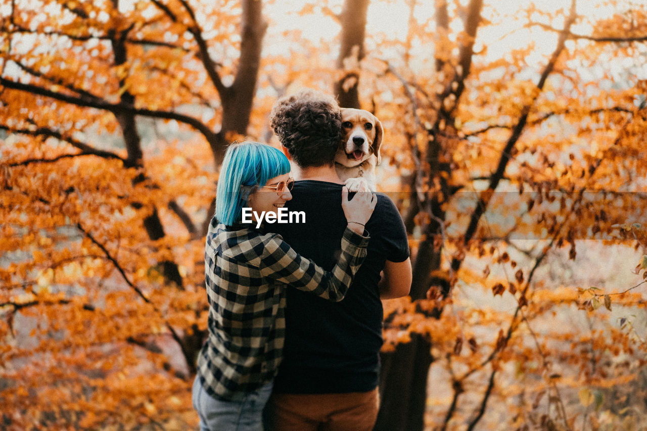 Couple standing by tree during autumn