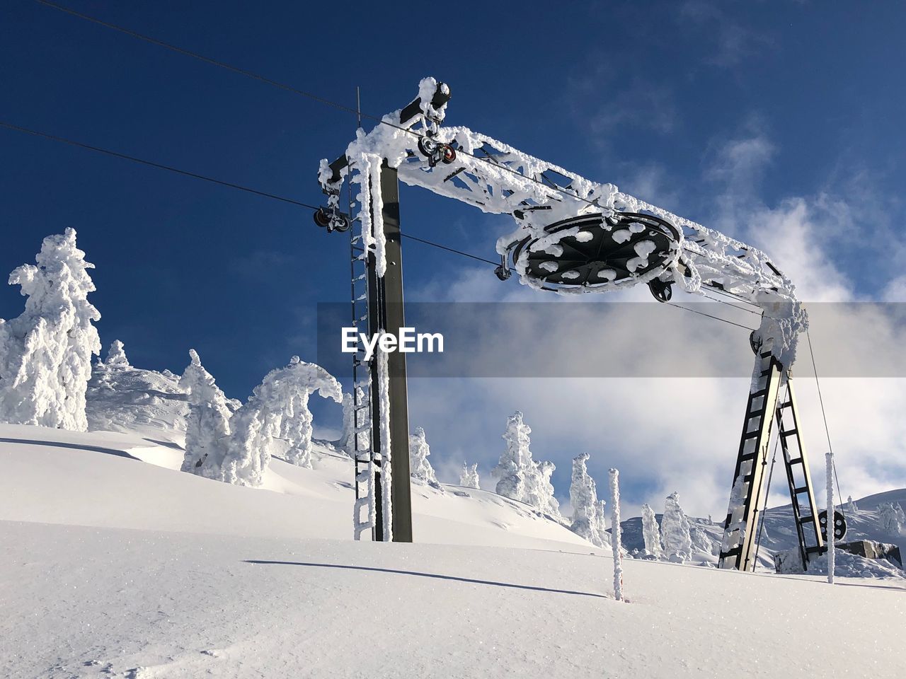 LOW ANGLE VIEW OF SNOW COVERED FIELD BY MOUNTAIN AGAINST SKY