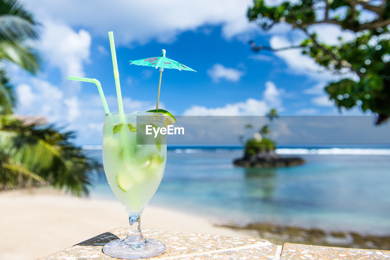 Close-up of drink on table against sea