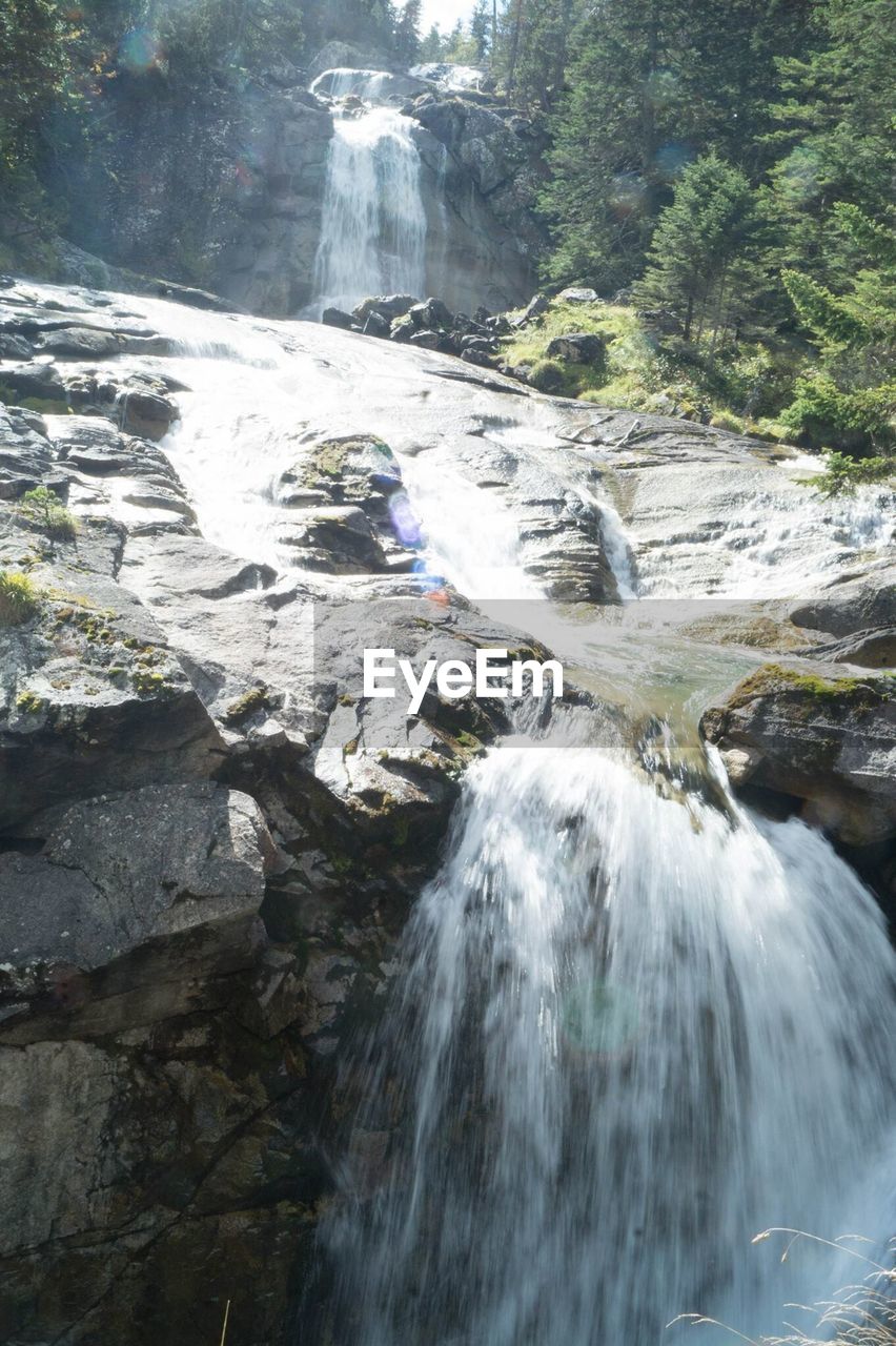 SCENIC VIEW OF WATERFALL ON MOUNTAIN