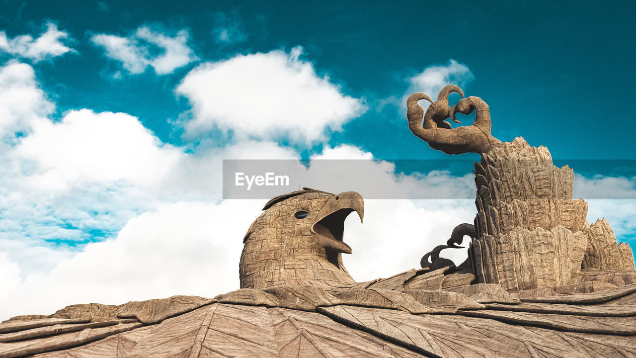 Low angle view of statue against cloudy sky