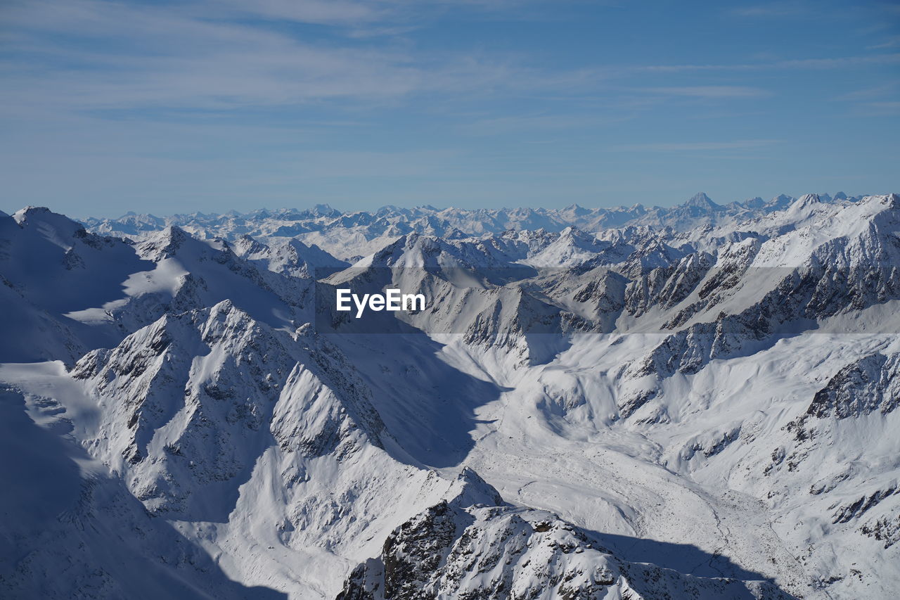 Aerial view of snowcapped mountains against sky