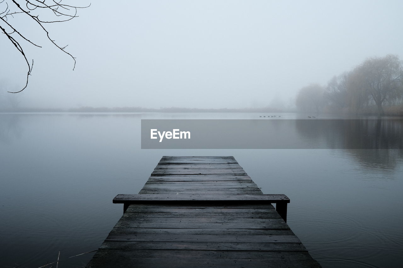 Pier over lake against sky