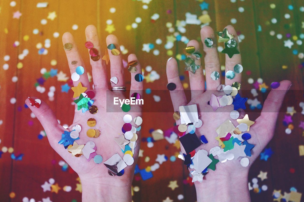 Cropped hands of woman with colorful confetti