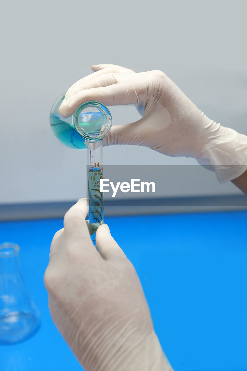 Cropped hand of person holding glassware at laboratory