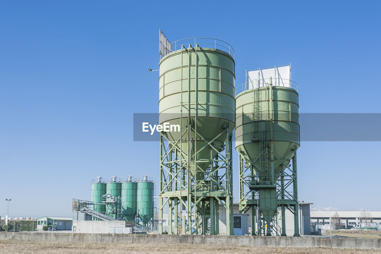 Low angle view of factory against clear blue sky