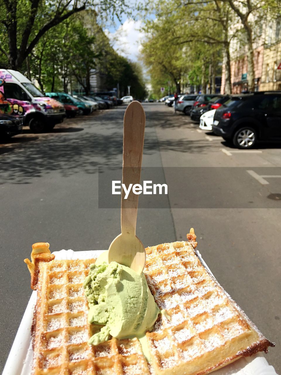 Close-up of waffle ice cream with cars parked at roadside