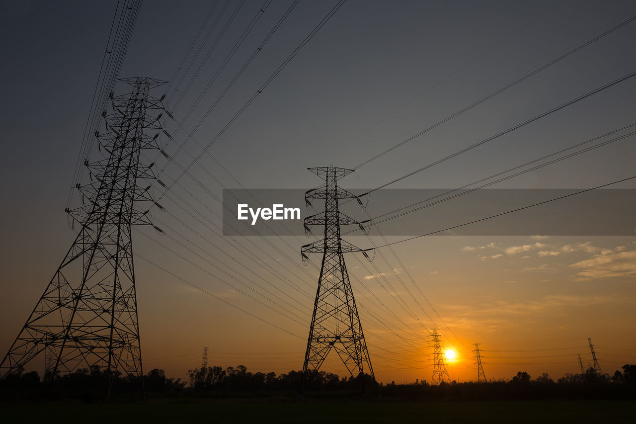 LOW ANGLE VIEW OF SILHOUETTE ELECTRICITY PYLON AGAINST SKY AT SUNSET