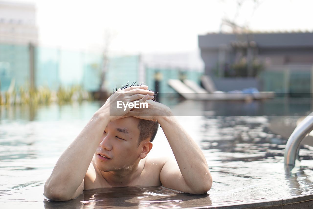 Shirtless man swimming in pool