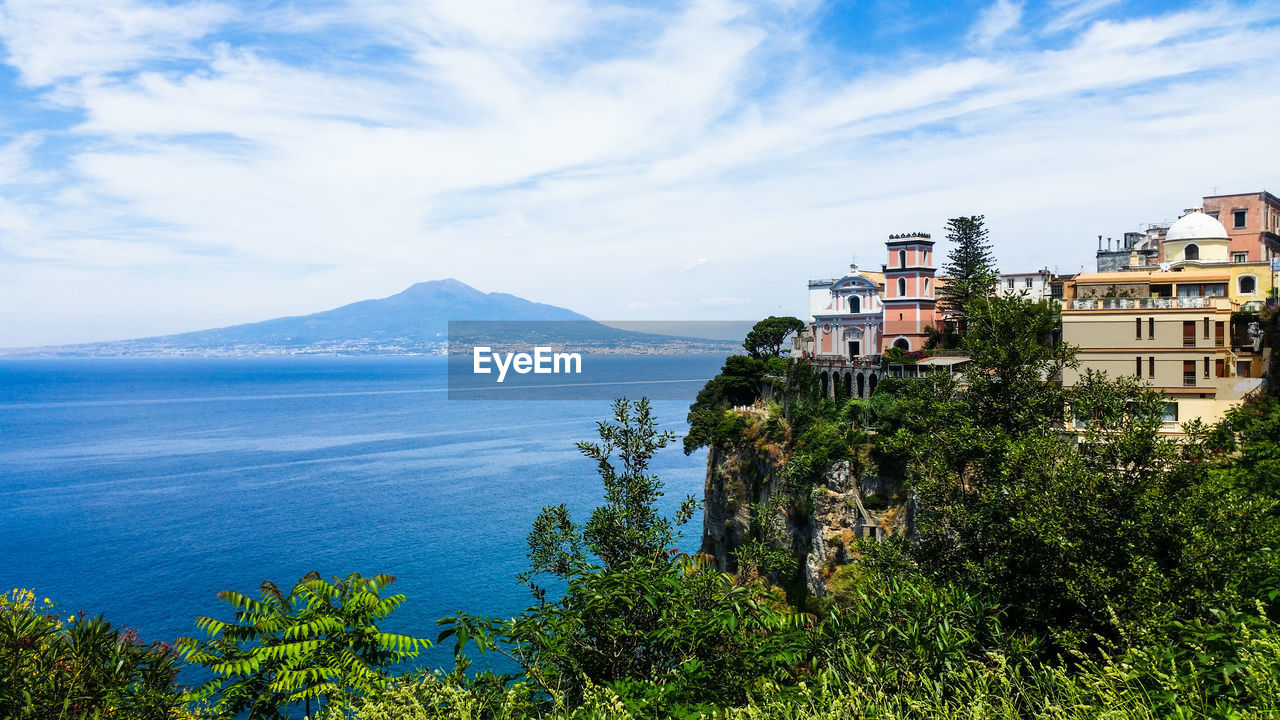 Scenic view of sea by buildings against sky