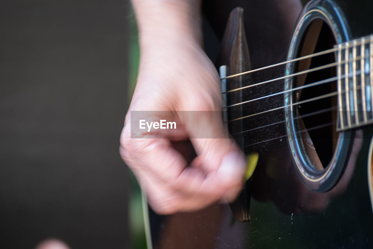 Close-up of man playing guitar