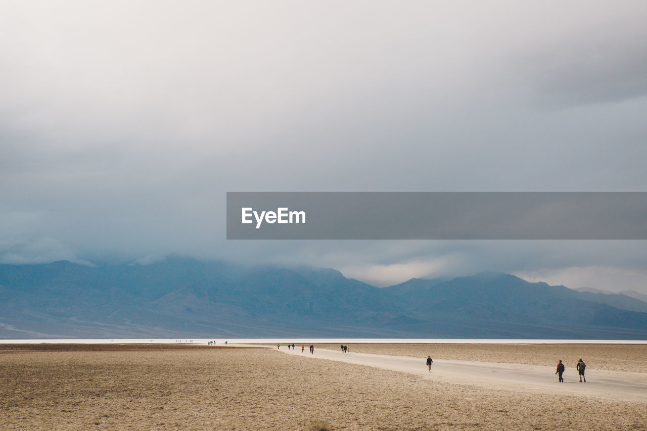 Scenic view of desert against cloudy sky