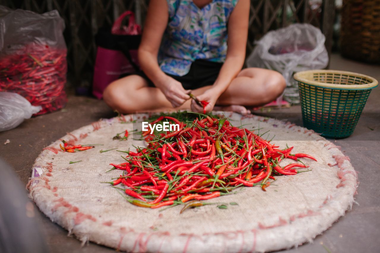 Low section of vendor with red chili pepper at market