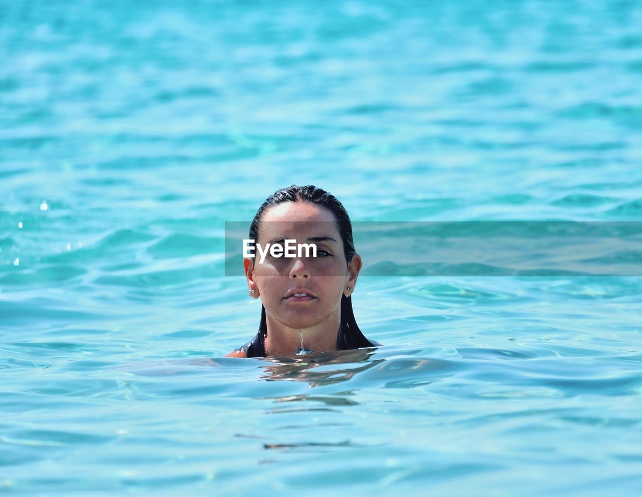 Portrait of young woman swimming in sea