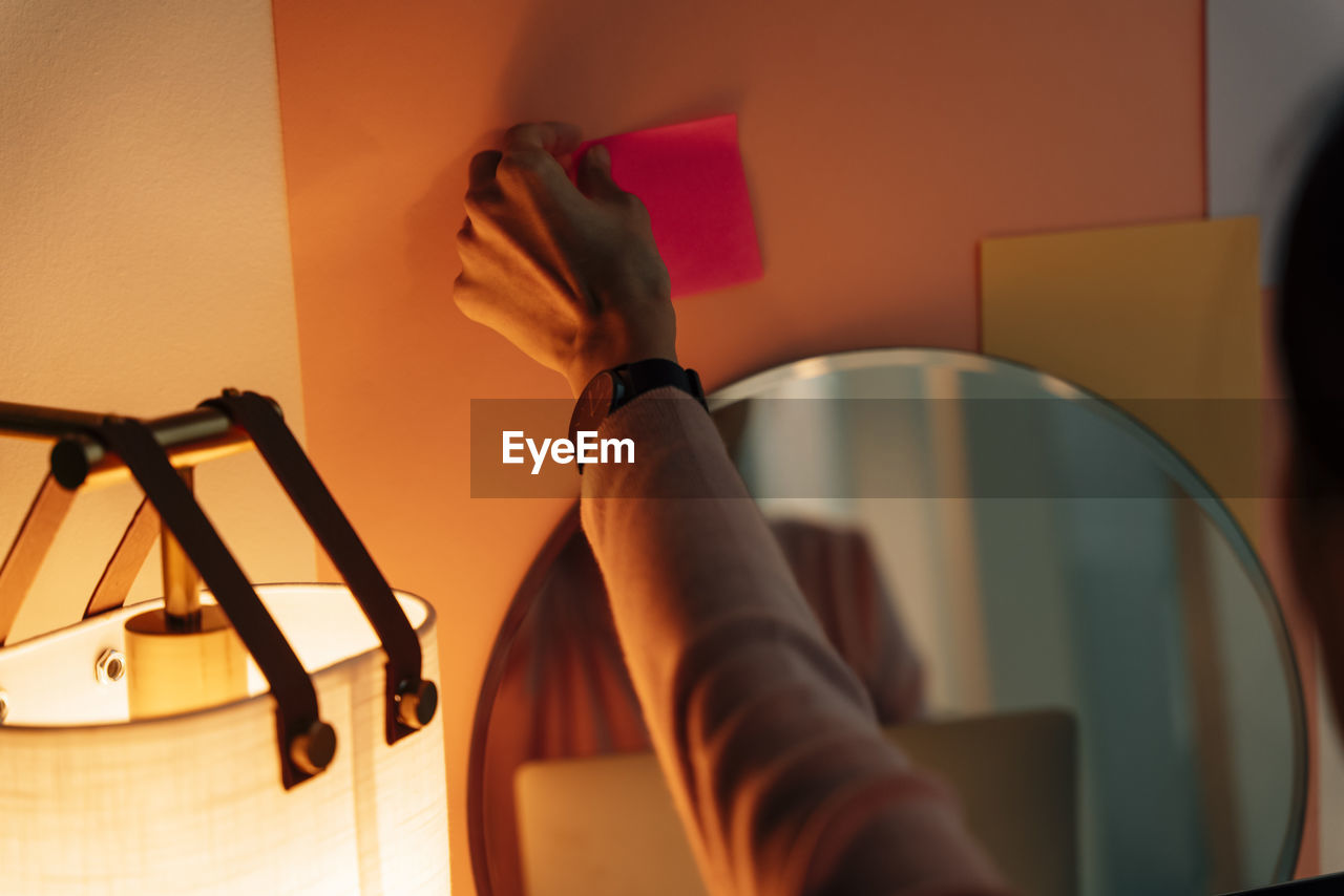 Cropped hand of woman holding adhesive tape in office