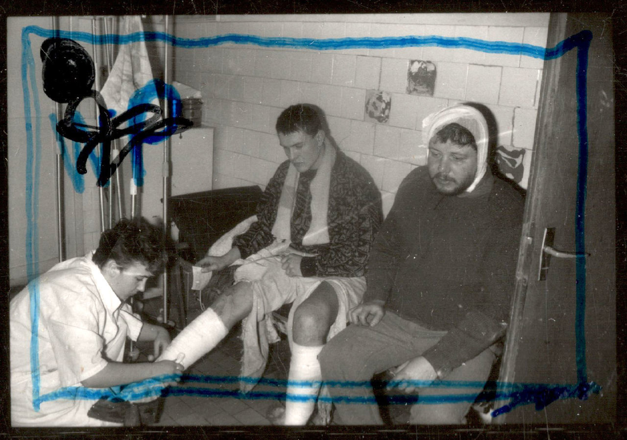 MEN SITTING ON FLOOR IN CITY AT NIGHT