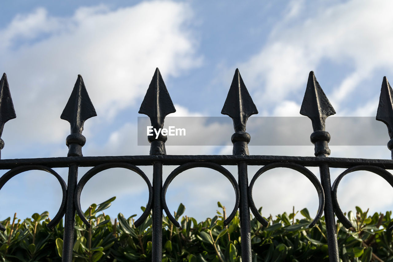 CLOSE-UP OF METAL FENCE AGAINST SKY